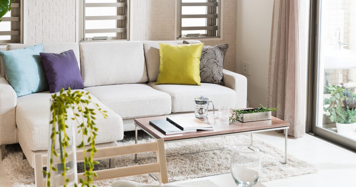 カラフルなクッションが映えるホワイトソファの明るいリビング