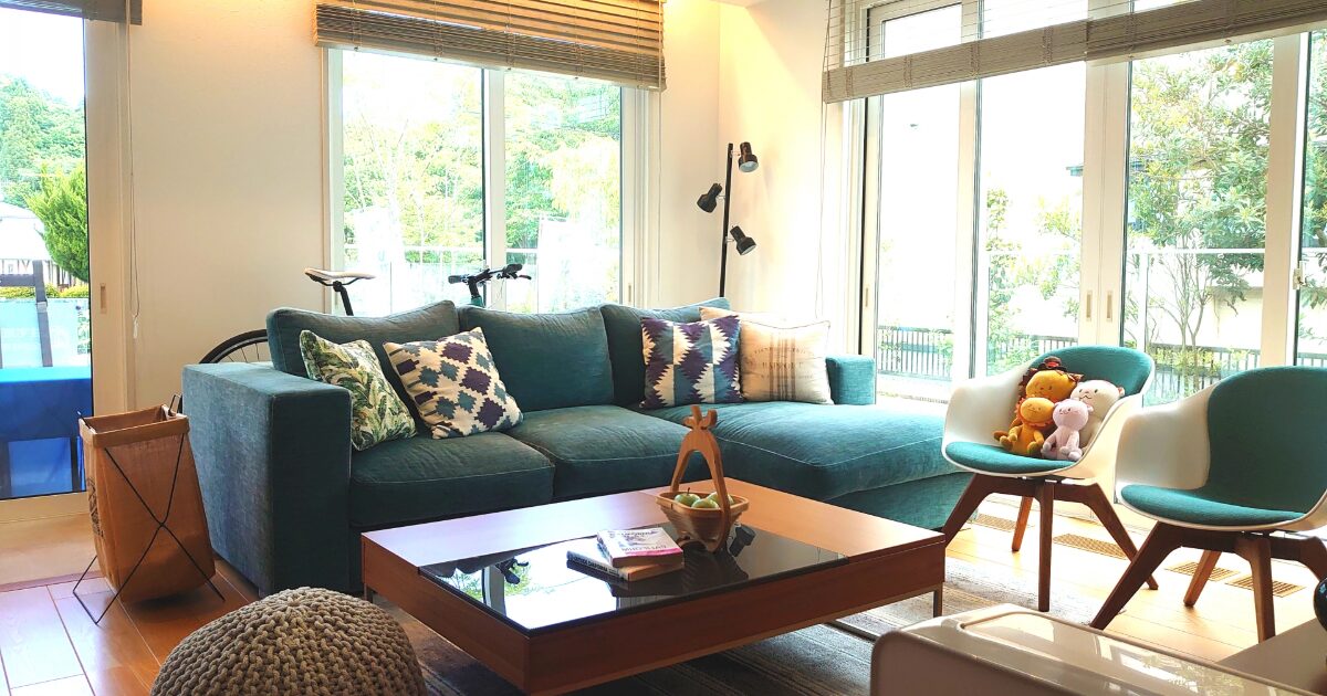 グリーンソファと大きな窓が特徴の明るく開放的なリビング