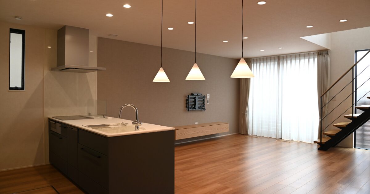ペンダントライトとアイランドキッチンがあるモダンなリビング空間