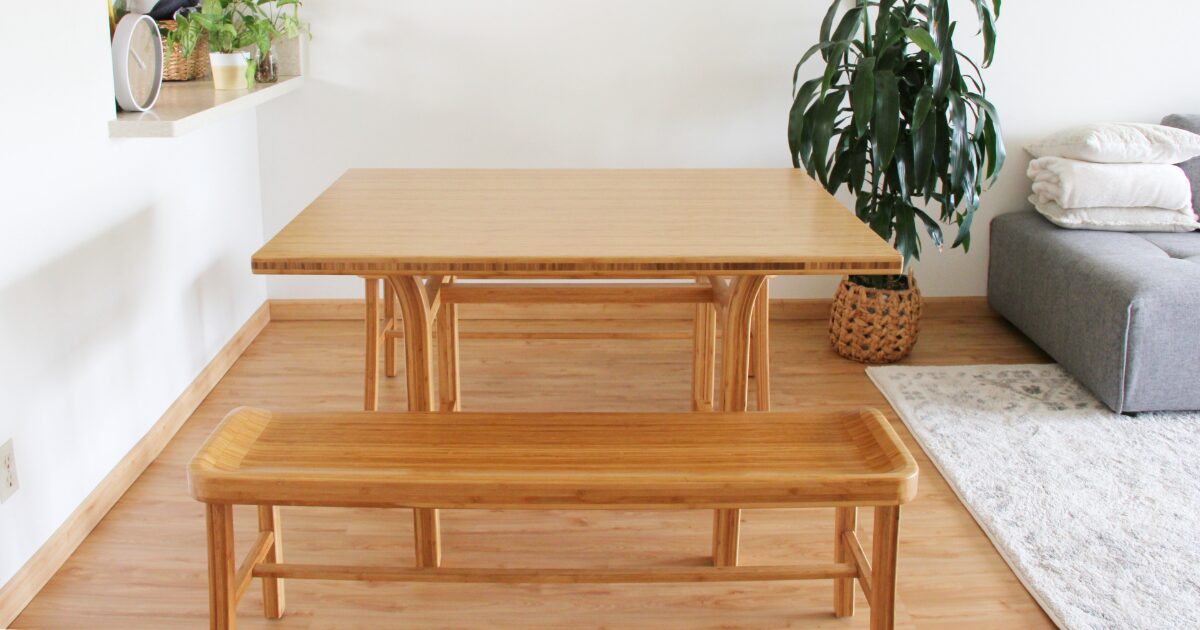 木製ベンチと観葉植物があるシンプルなダイニングスペース